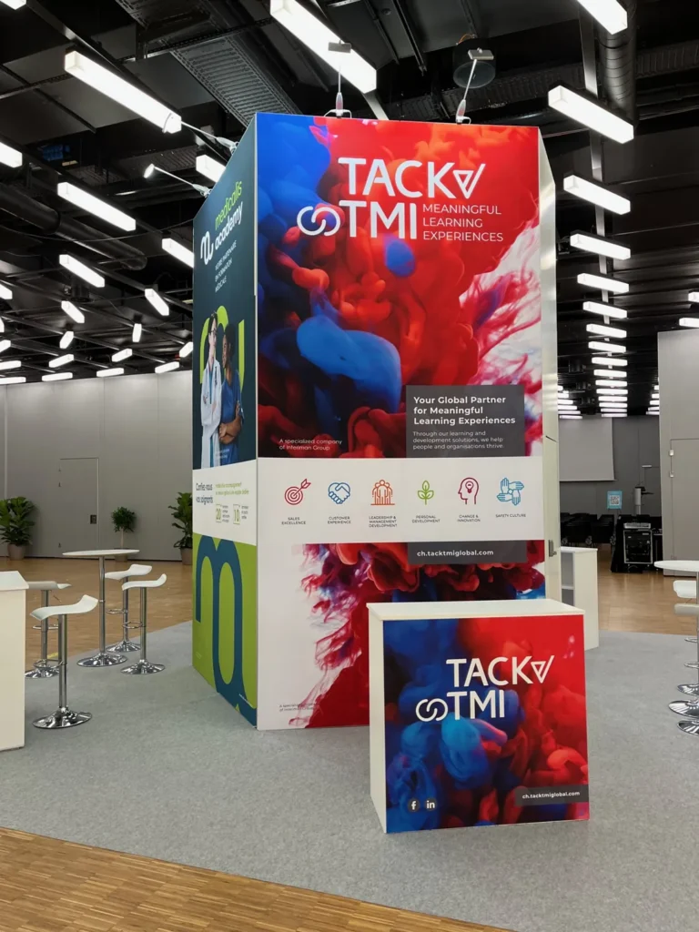 Stand tour pour TACK TMI et Medicalis Academy (Groupe Interiman) à Palexpo Genève, avec visuels imprimés sur tissu et comptoir personnalisé